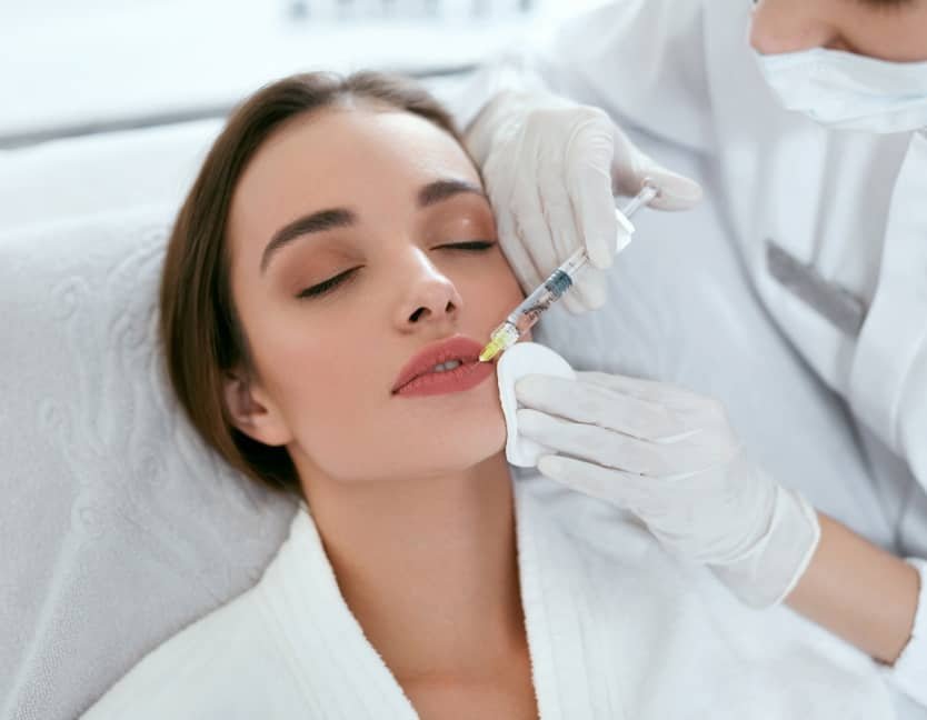 Patiente recevant une injection levres à l’acide hyaluronique en institut spécialisé